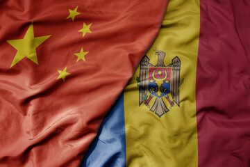 big waving national colorful flag of china and national flag of moldova .