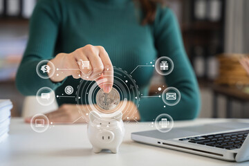 Woman sitting at desk managing expenses, calculating expenses, paying bills using laptop online, making household financial analysis, closer focus on the white piggy bank.