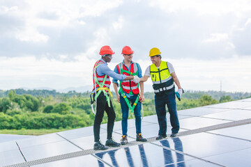 Obraz premium Professional technicians carrying photovoltaic solar moduls on factory roof, Engineers in helmets installing solar panel system outdoors. Concept of alternative and sustainable renewable energy.