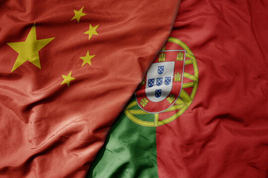 big waving national colorful flag of china and national flag of portugal .