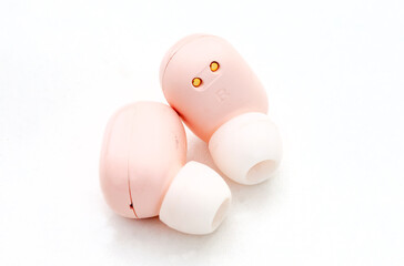 Light pink colored in-ear wireless earphones isolated on white 