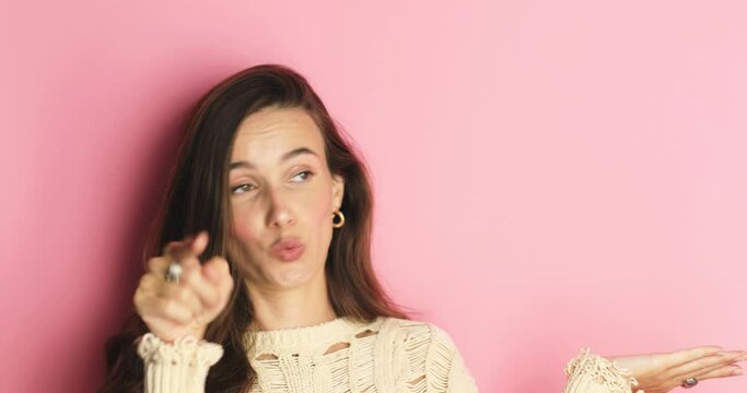 Excited woman make hi gesture, point on you, look at side, say wow and pointing hands aside, thumb up isolated on pink background. Look over here. Sale here. Attention! You need it!