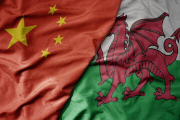 big waving national colorful flag of china and national flag of wales .