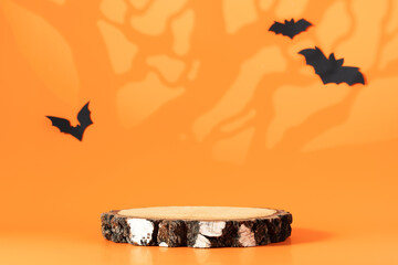 Creative Halloween composition with paper bats, podium and orange background. Modern Halloween...