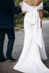 Bride and groom holding hands and walking in park