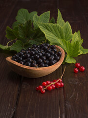 black currant and red currant on a wooden background.