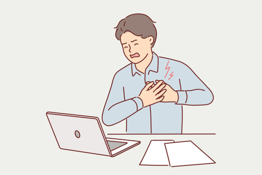 Businessman clutching heart feeling pain or infarct doing paperwork sitting at office desk