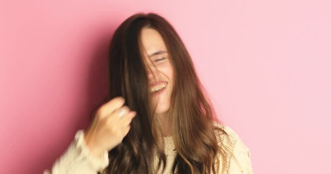 Brunette girl shocked, saying WOW. Pretty excited woman smiling, jumping, pleasantly surprised to camera isolated pink background. Winning girl celebrate jumping with ecstatic face expressions. 