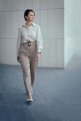 Young caucasian model woman in office or business fashion style pantsuit in brown tones, copy space, vertical.