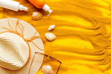 Beach accessoties with sunscreen cosmetic and straw hat. Summer beach concept flatlay