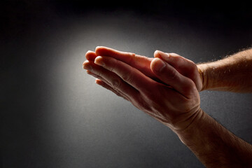Praying hands with palms together isolated dark top view