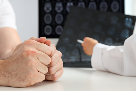 The doctor shows the tumor to the patient on MRI images of the head