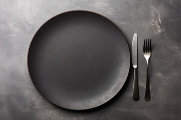 An empty black plate with cutlery on a dark concrete background. Home dinner cooking on stone table. Top view with copy space. Generative AI. - obrazy, fototapety, plakaty
