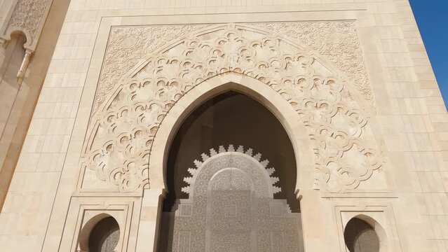 Looking up at decorative details of Hassan ii mosque marble archway gate and building exterior architecture, Morocco