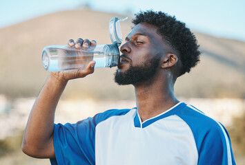 Black man, fitness or soccer player drinking water in training, exercise or workout in football...