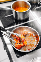 cooking chicken wings in a sauce in the kitchen