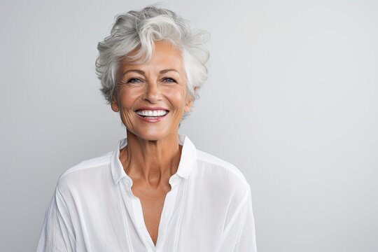 Beautiful gorgeous 50s mid age beautiful elderly senior model woman with grey hair laughing and smiling. Mature old lady close up portrait. Healthy face skin care beauty, skincare cosmetics, dental.