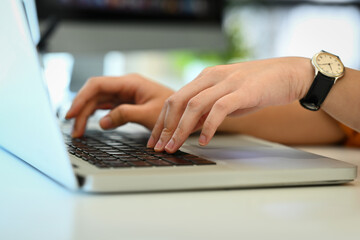 Unrecognizable woman hands typing on laptop keyboard, working in office or browsing information