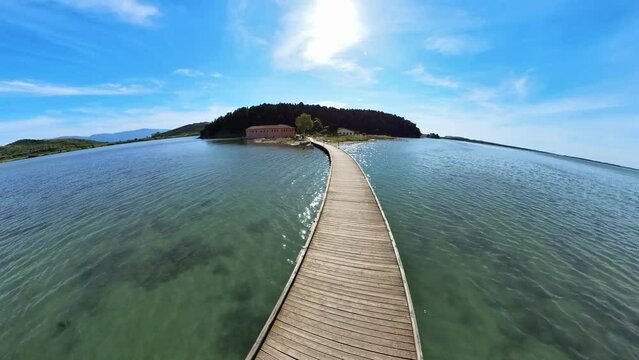 Drone view of pedestrian bridge to Zvernec Islands, hidden gem in Albania, offering a unique blend of history, spirituality, and natural beauty that captivates those who have the opportunity to visit.