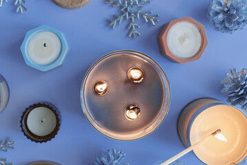 Burning candles on blue background. Winter and Christmas season, top view - 627252839
