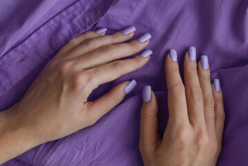Female's hands with gelish manicure and nails of purple color. Lavender fingernails. Permanent nail polish - 627252861