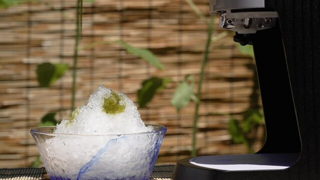 夏の陽射しの中かき氷に抹茶シロップをかけるシーン / 夏休み・昭和レトロ・日本の夏の風物詩イメージ