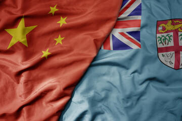 big waving national colorful flag of china and national flag of Fiji .