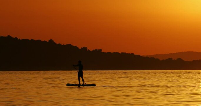 Stand up paddling on sunset, the Adriatic Sea near Zlarin Island, Croatia