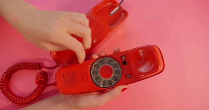 Woman using a vintage red telephone