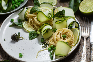 Pasta with zucchini and green peas in a bowl