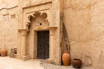 Old historic district in Dubai. Ancient arabic wooden front door framed by an oriental arc. Door...