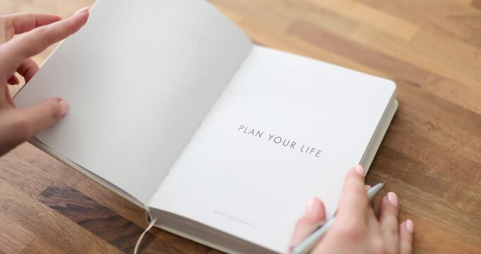 Woman writes text plan of life diary writing note with pen in notebook. Planning for future