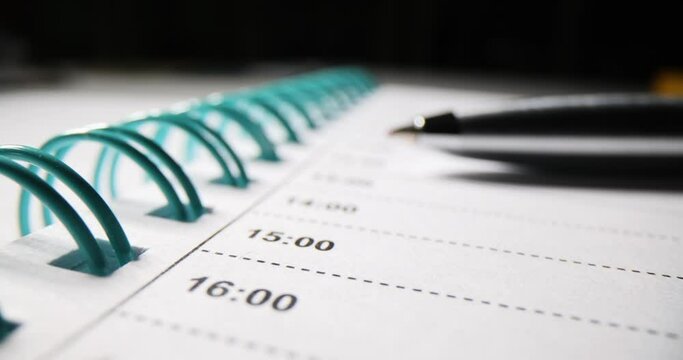 Blank white open diary planner with pen lies on table. Working time planning