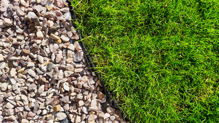Gravel and lawn in home garden. Gardening concept background. Lawn edge close up summer