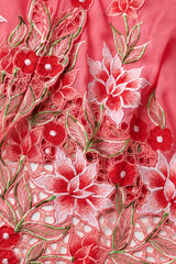 Red kebaya cloth with intricate embroidery of red flowers.