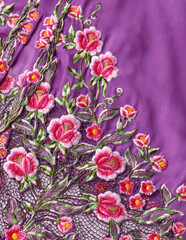 Purple kebaya cloth with intricate embroidery of pink flowers.