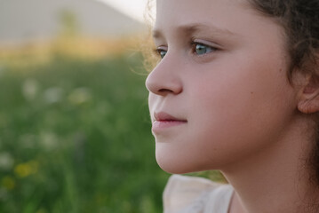 Close up portrait of adorable smiling little girl outdoors in summer. Cute preteen child enjoying beautiful warm sunny day on background mountains during sunset. People freedom and childhood concept