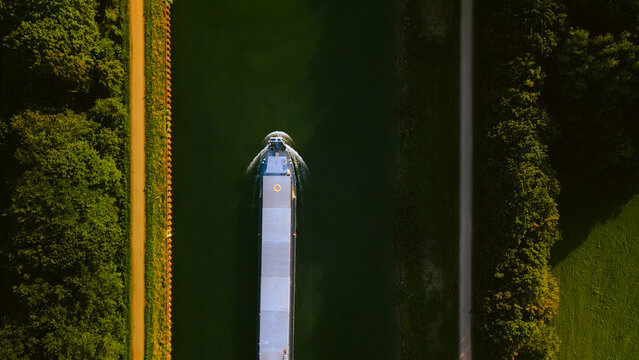 Aerial view of global shipping cargo ship navigating through the inland canal.