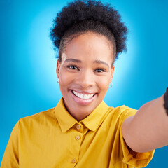Happy woman, face and portrait smile for selfie, photography or memory against a blue studio background. African female person or photographer smiling for picture, photo or online social media post