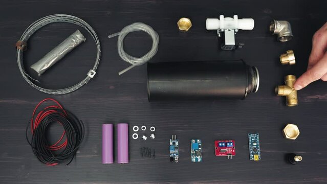 DIY Creations: Young Man Showcasing Top-View Maker Materials and Projects