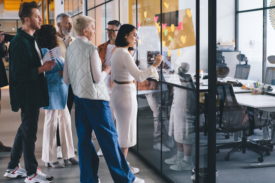 Professional trade experts planning exchange discussing together experience during collaborative meeting in office interior with glass board for informative planning, colleagues during working process