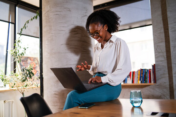 Black businesswoman working on laptop. Portrait of beautiful businesswoman sitting on the desk.
