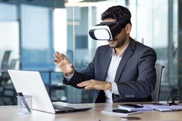 Businessman using vr glasses to view educational material and financial documents, graphs and tables online, financier inside office at workplace.