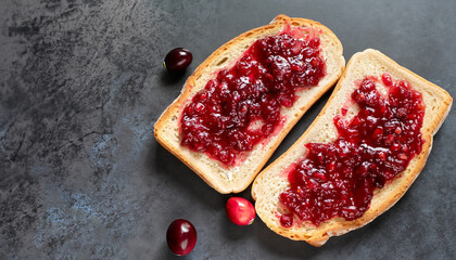 Cranberries jam. Crispy sandwich with cranberry sauce on dark background. Top view.