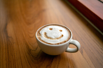 Cup of cappuccino coffee delicious hot coffee with foam milk and smile on color background, top view. Happy morning, good mood, inspiration