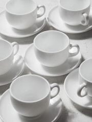 Background from a set of white ceramic dishes, cups and saucers for tea or coffee