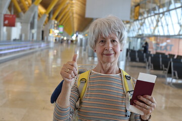Senior woman giving a thumbs up form transportation terminal 