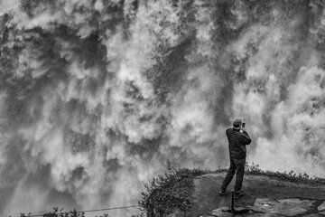 Scenery black and white panoramic perspective near Dettifoss, one of the biggest European waterfall, Iceland. Male tourist takes photos.