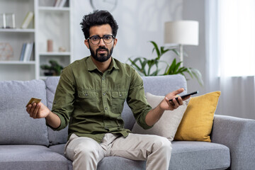 Dissatisfied and disappointed indian man cheated online by scammers robbers, looking at camera, man...
