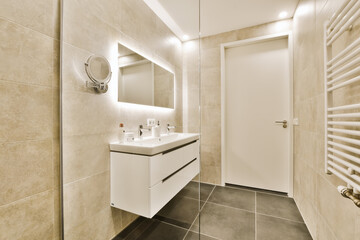 Obraz na płótnie Canvas a modern bathroom with tile flooring and white fixtures on the wall, mirror in the corner to the left